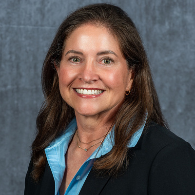 smiling woman, Maralyn, wearing glasses and business attire