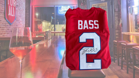 Buffalo Bill Tyler Bass autographed jersey over a scene from a bar
