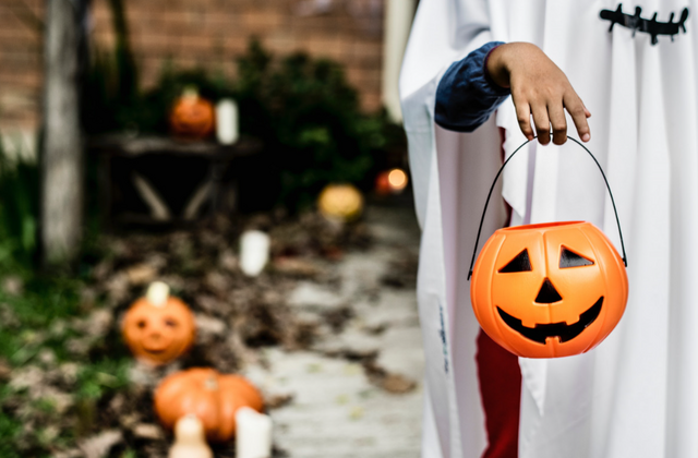 trick or treater holding pumpkin basket