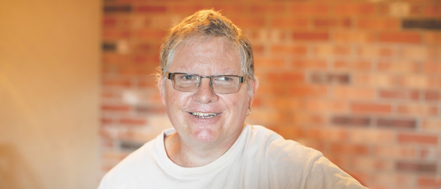 Contact Us Have a question? We're here to help! with photo of man with glasses smiling
