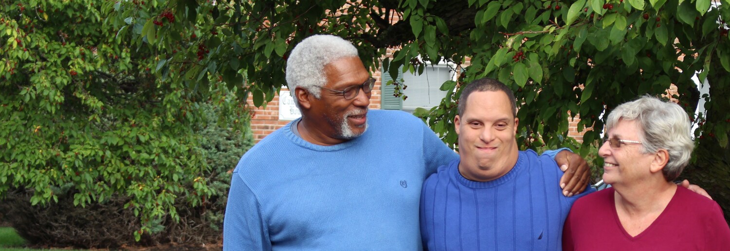 three people smiling: a white young man, an Asian man and an African American woman