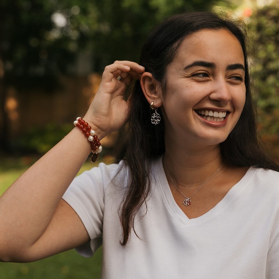 Young woman displaying earrings, bracelet and necklace.