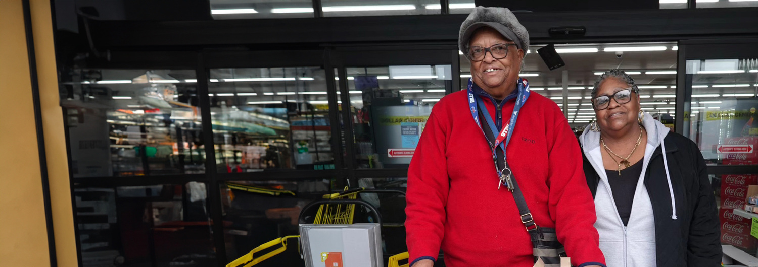 Volunteers and Interns I had a few hours to spare. I gained a lifetime friend. photo shows two older Black women standing in front of a grocery store entrance.