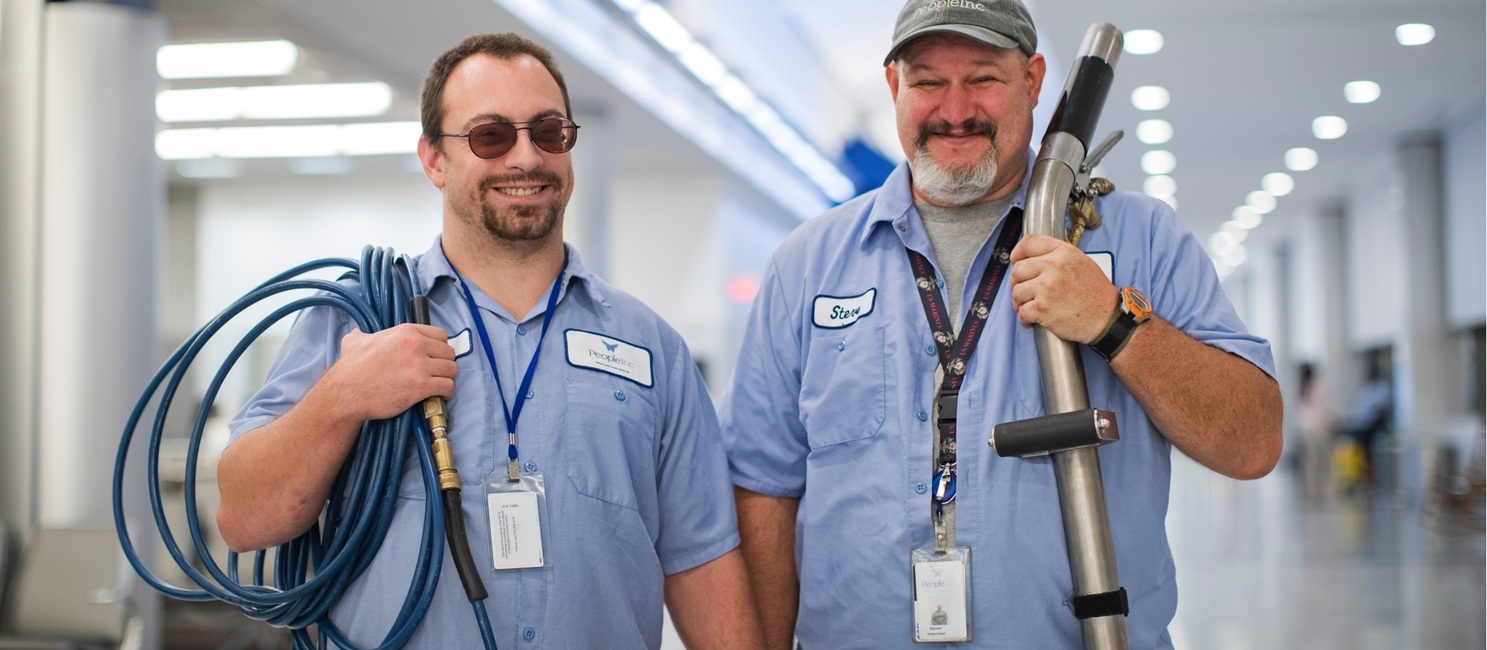 two men holding equipment used in commercial janitorial cleaning