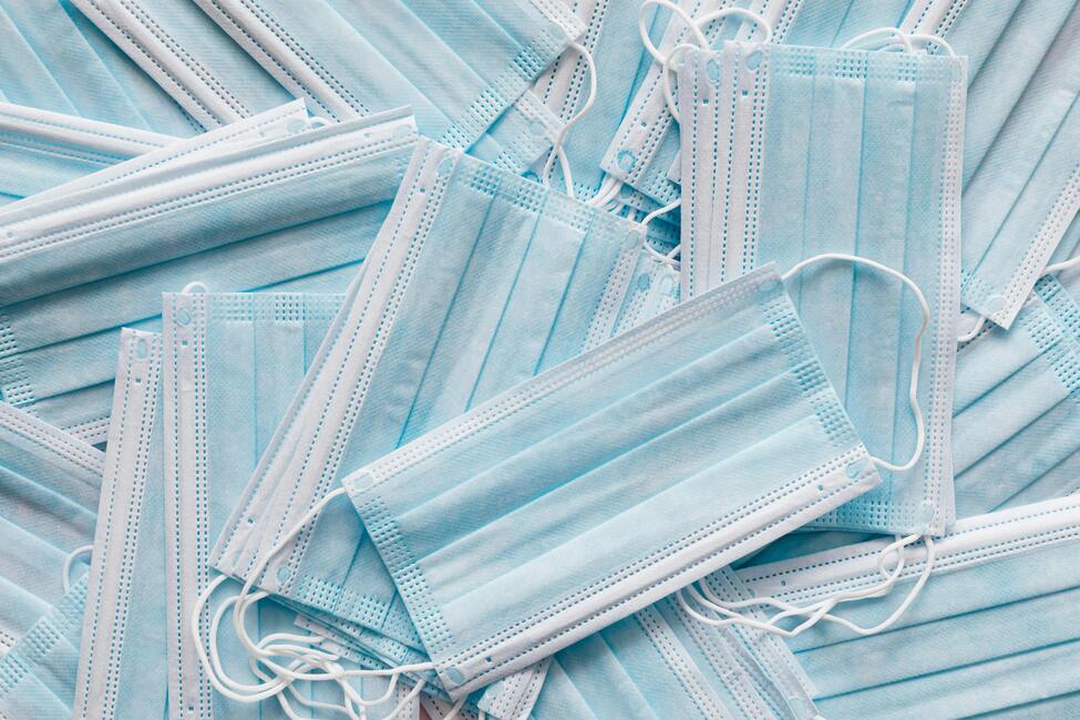 A pile of pale blue medical face masks