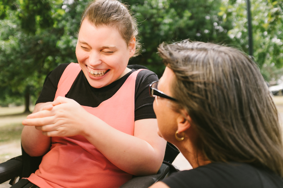 Young woman and adult woman sharing a laugh