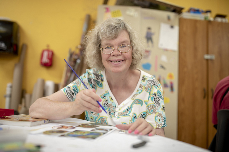 Smiling woman painting a picture