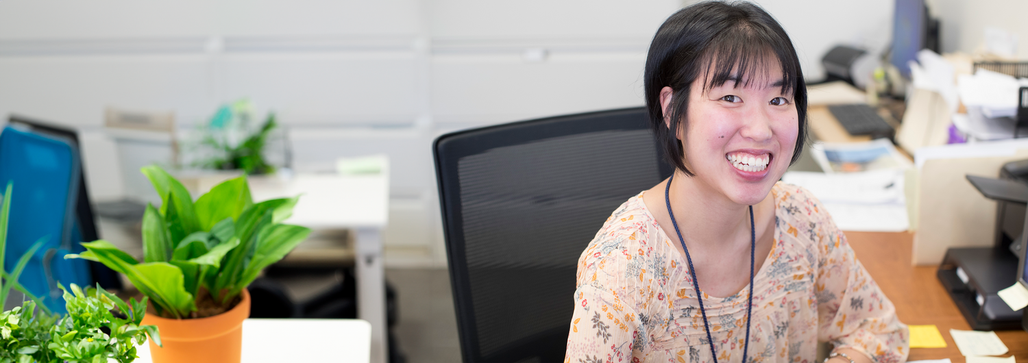 Asian young lady working at a computer smiling