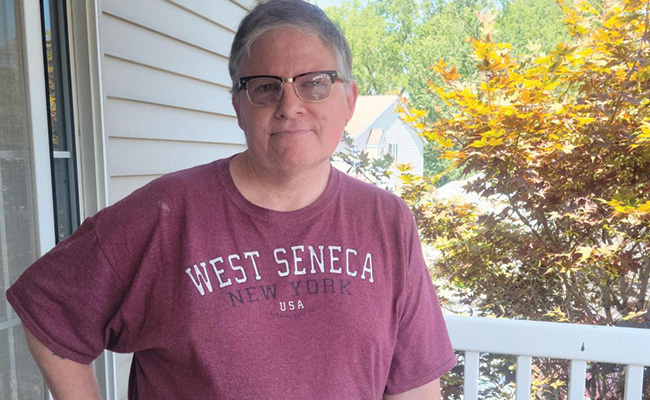 Robert stands outside of his apartment