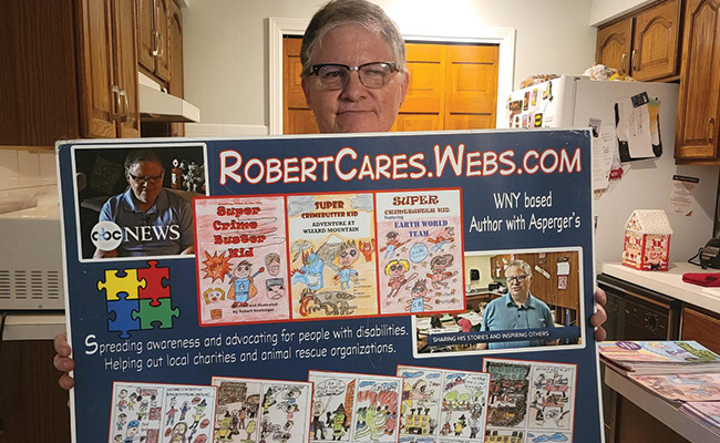 Robert holds up a poster displaying images of his work, his mission and website