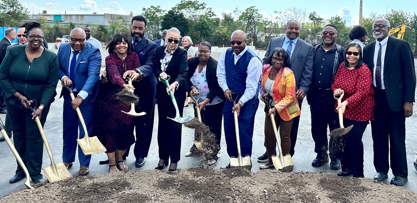 Twelve people who represent Mt. Olive Development Corporation, Mt. Olive Church and community leaders, scooping dirt with shovels as part of the ceremonial Mt. Olive Senior Manor groundbreaking.