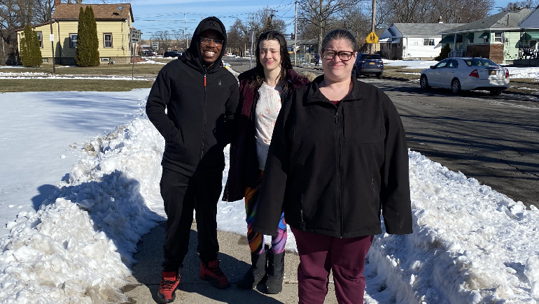 Three people walking outside on a bright winter day