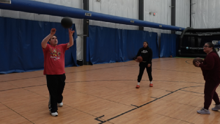 Three people shooting basketballs