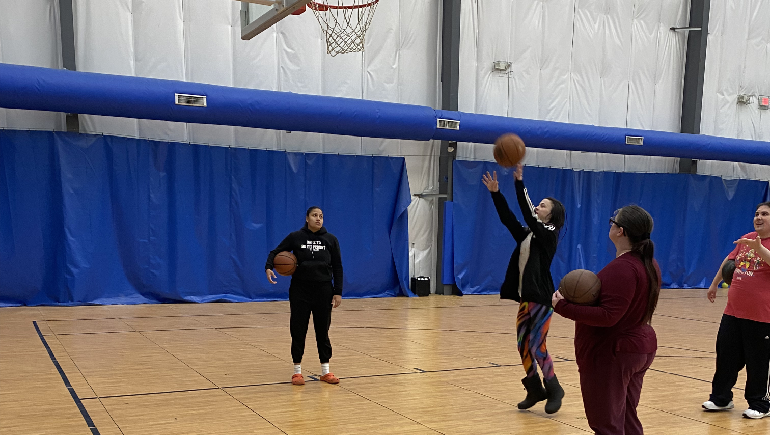 Four people practicing their basketball throws